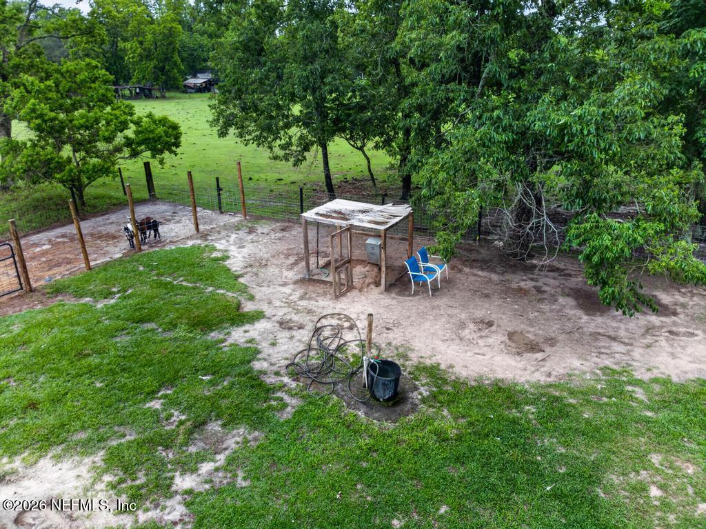 2955 Carroll Corner Road Hilliard, FL 32046 - Photo 102 of 106 a view of a backyard with table and chairs and a fire pit