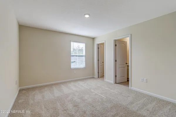an empty room with windows and closet