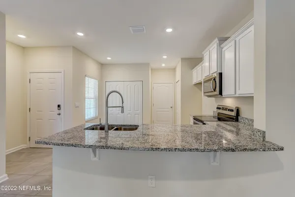 a kitchen with granite countertop a sink and a stove top oven