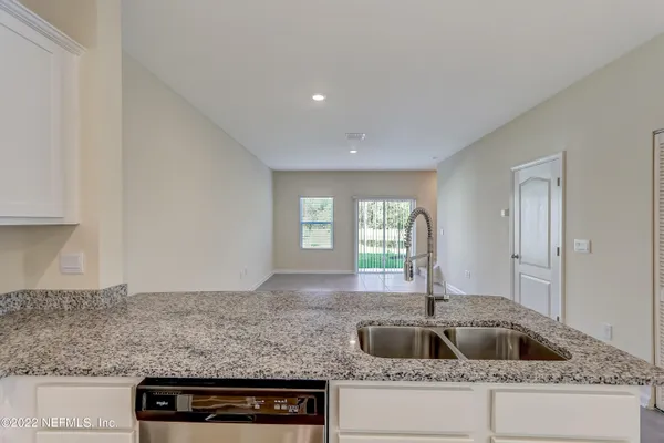 a kitchen with granite countertop a sink and a wooden floor