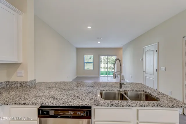 a kitchen with granite countertop a sink and a wooden floor