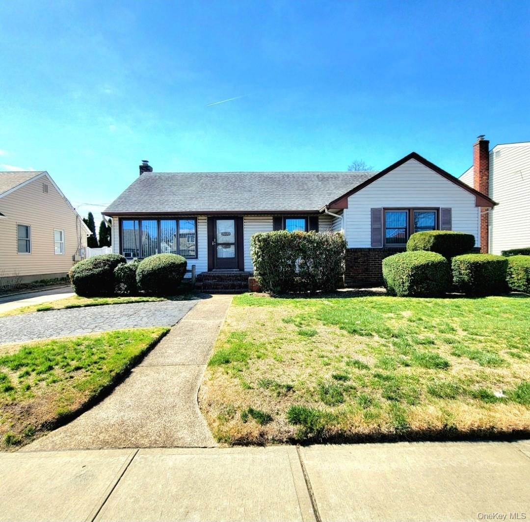 a front view of a house with a yard and potted plants