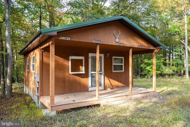 a front view of a house with wooden fence and a yard