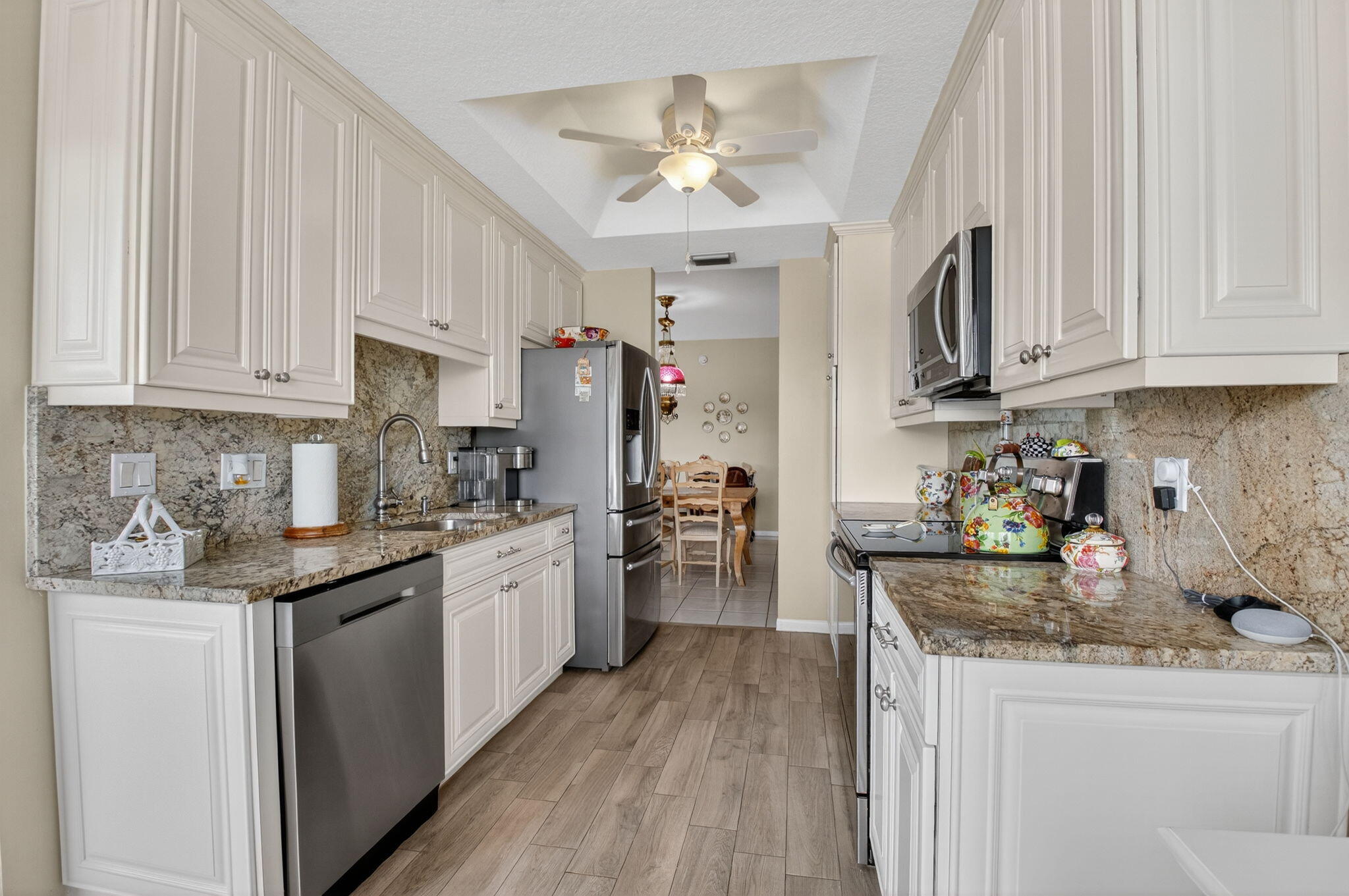17287 Boca Club Boulevard, Unit 1 Boca Raton, FL 33487 - Photo 11 of 28 a kitchen with a sink dishwasher a stove a refrigerator and cabinets with wooden floor