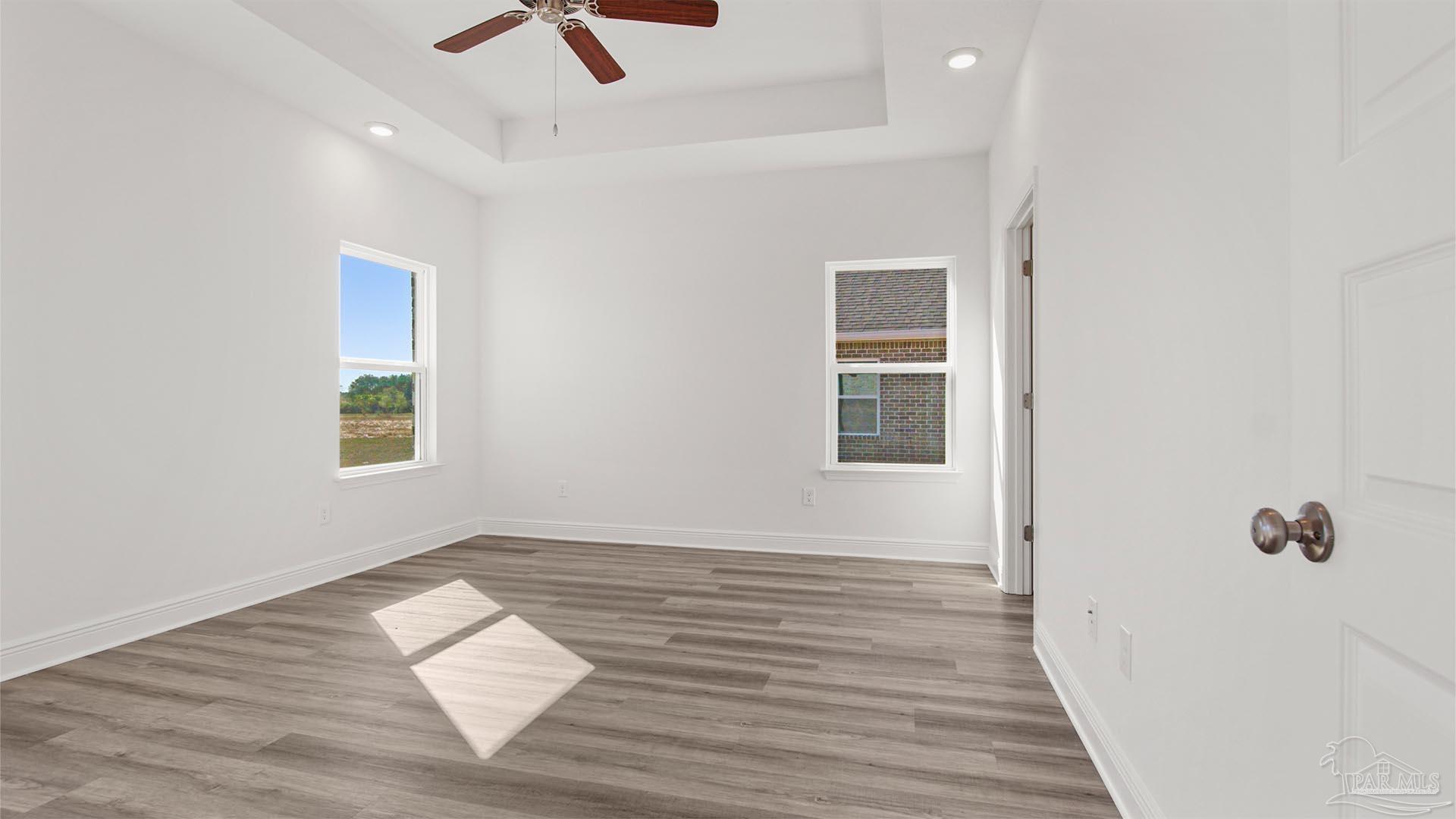 8664 Bluebell Street Milton, FL 32583 - Photo 11 of 28 an empty room with wooden floor and windows