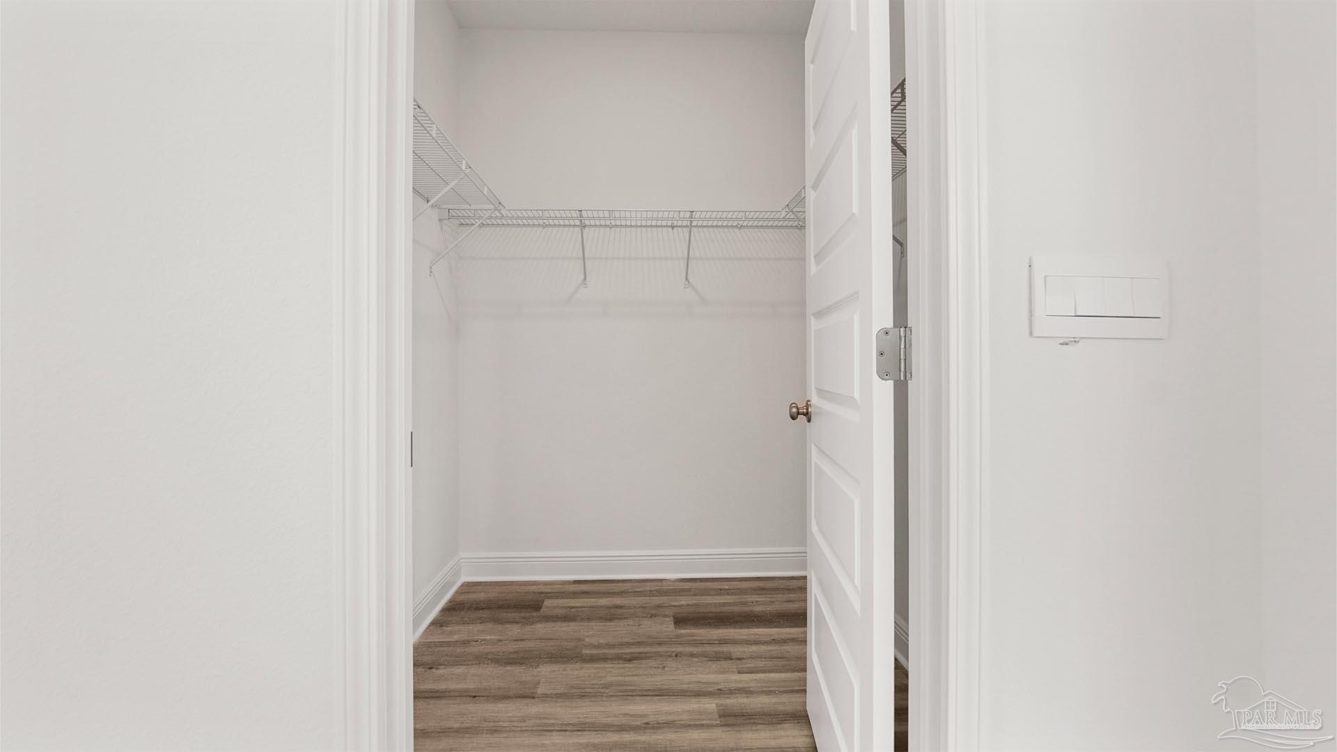 8664 Bluebell Street Milton, FL 32583 - Photo 18 of 28 a view of an empty walk in closet with empty racks