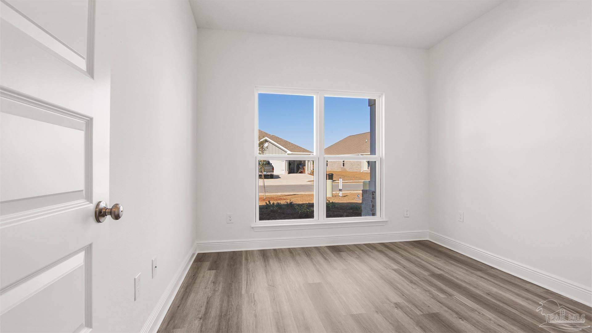 8664 Bluebell Street Milton, FL 32583 - Photo 23 of 28 a view of an empty room with wooden floor and a window