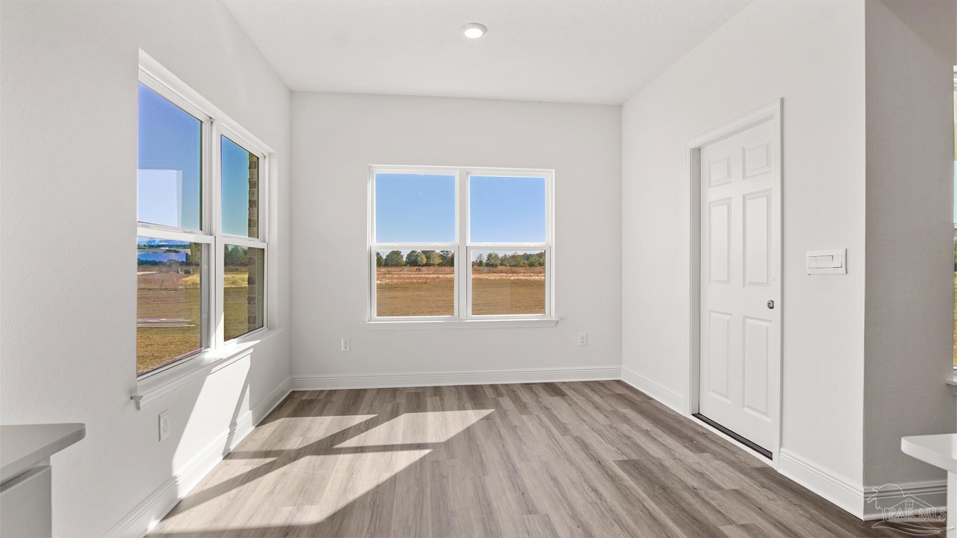 8664 Bluebell Street Milton, FL 32583 - Photo 10 of 28 a view of an empty room with wooden floor and a window