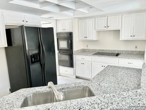 a kitchen with stainless steel appliances kitchen island granite countertop a refrigerator a sink a stove a microwave and island