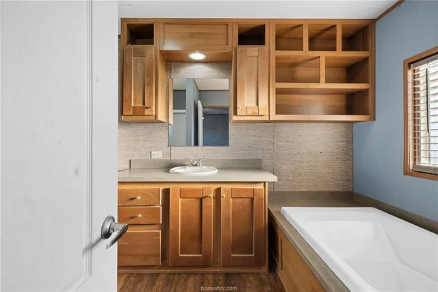 a bathroom with a granite countertop toilet sink and mirror
