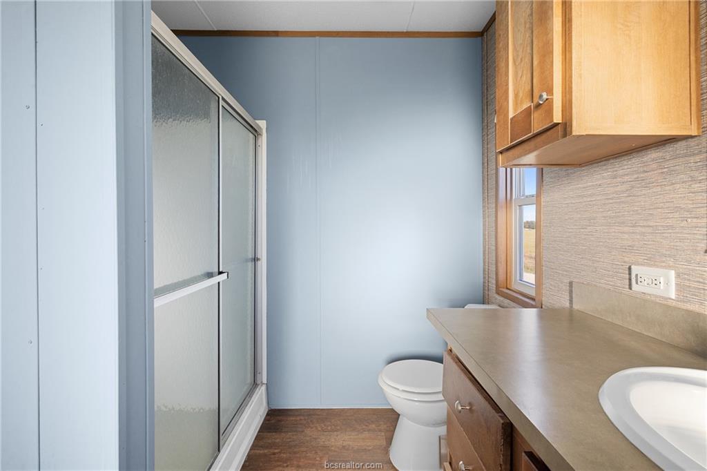 2361 Smetana Road Bryan, TX 77807 - Photo 9 of 32 a bathroom with a granite countertop toilet sink and mirror