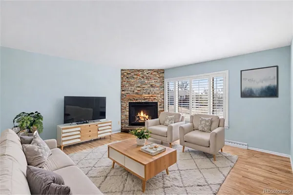 a living room with furniture a flat screen tv and a fireplace