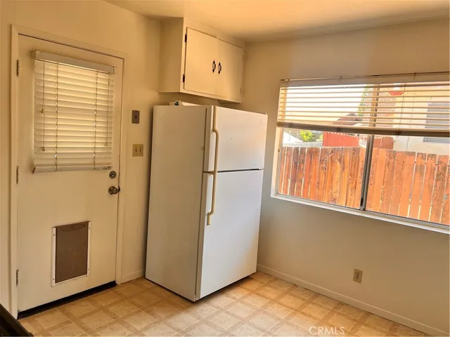 a view of a refrigerator in kitchen and a window