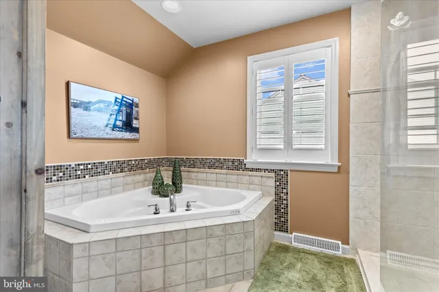 a spacious bedroom with a bed and glass window