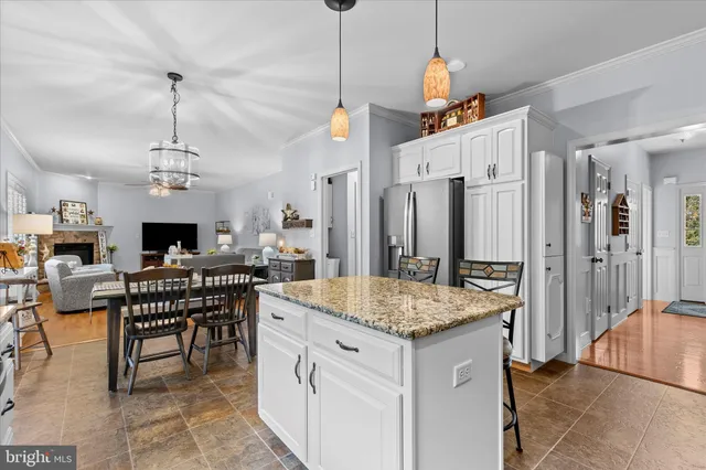 a open kitchen with stainless steel appliances granite countertop a stove a kitchen island a dining table and chairs