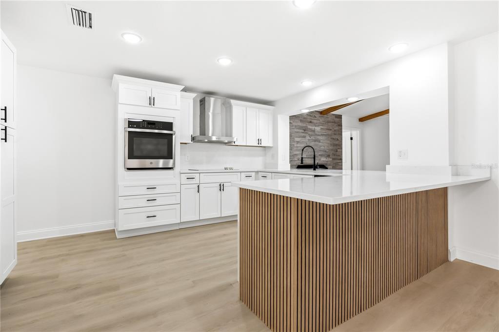 1985 Japonica Road Winter Park, FL 32792 - Photo 18 of 51 a kitchen with stainless steel appliances a microwave a stove and white cabinets