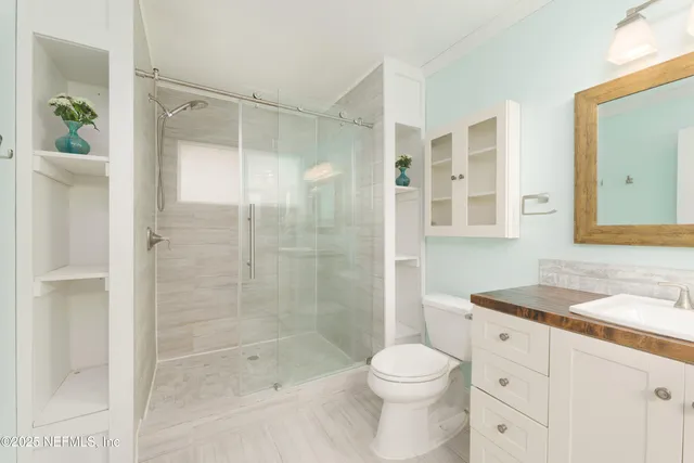 a bathroom with a sink a toilet and shower