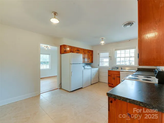 a kitchen with stainless steel appliances granite countertop a sink and a refrigerator