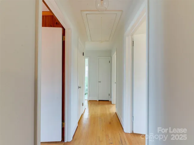 a view of a hallway with wooden floor