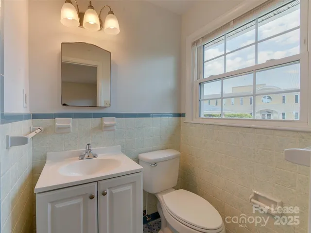 a bathroom with a sink a toilet and a mirror