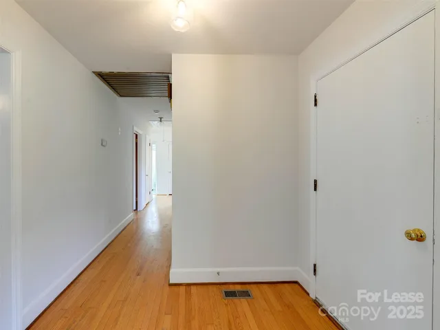 a view of a hallway with wooden floor