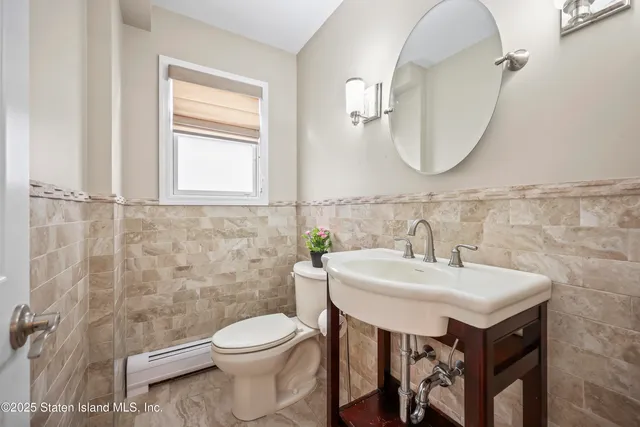 a bathroom with a sink a toilet and a mirror