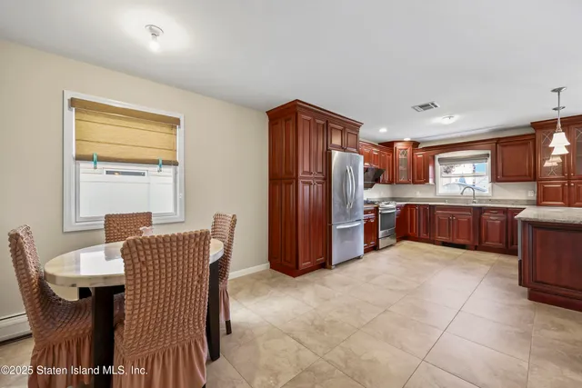 a kitchen with stainless steel appliances wooden cabinets a dining table and chairs