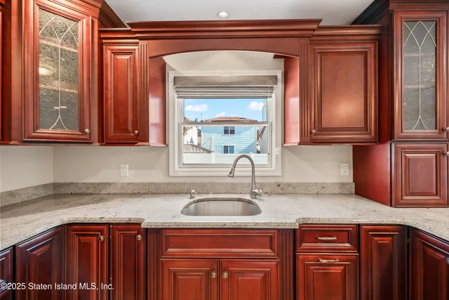 a kitchen with stainless steel appliances granite countertop a sink and cabinets with wooden floor