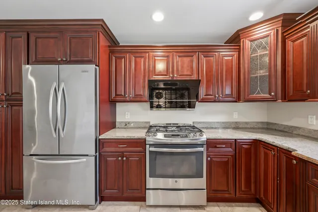 a kitchen with stainless steel appliances granite countertop a refrigerator stove and sink