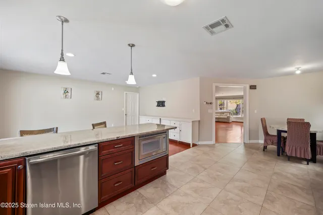 a large kitchen with kitchen island a sink stainless steel appliances and cabinets