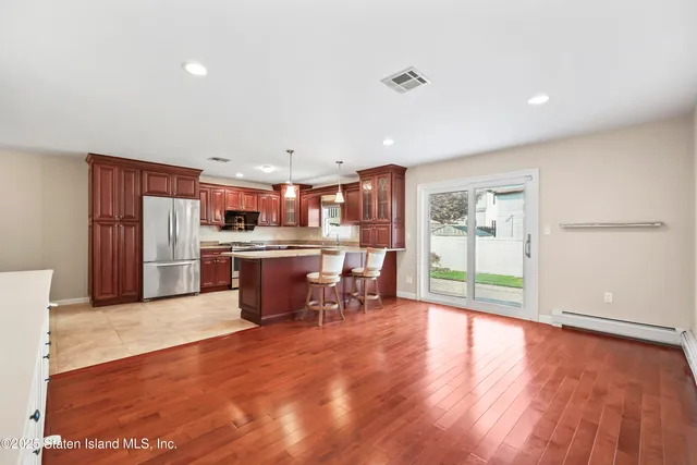 a kitchen with stainless steel appliances a refrigerator and wooden floor