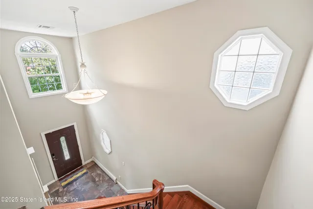 a bedroom with a large bed chandelier and a window