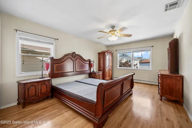 a bedroom with a bed lamp and a potted plant