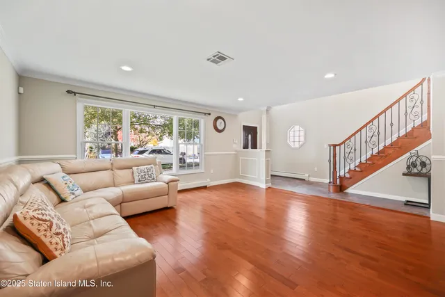 a living room with furniture and hard wood flooring