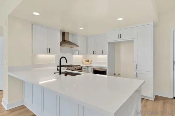 a kitchen with stainless steel appliances granite countertop a sink a stove and a refrigerator