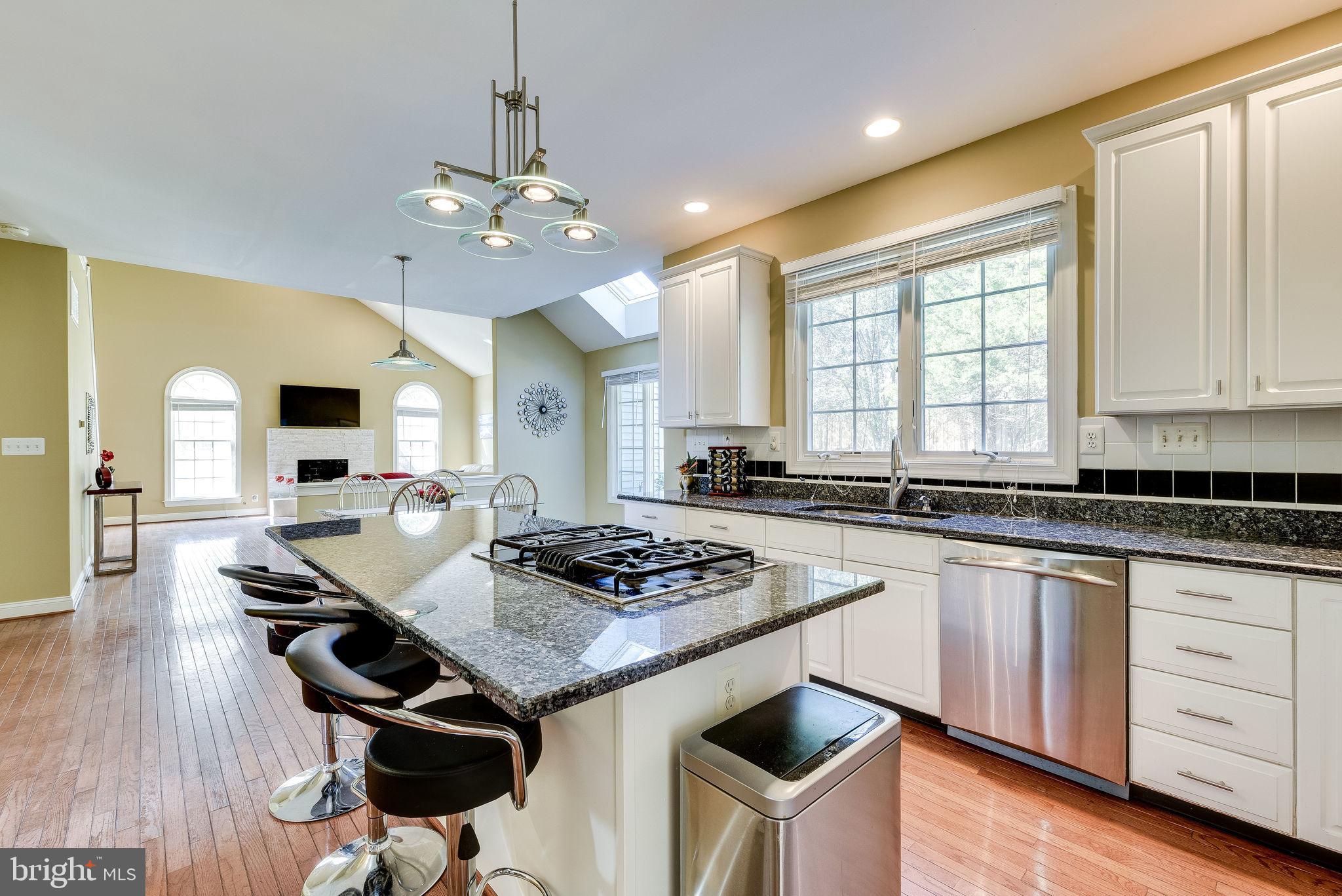 1701 Raleigh Hill Road Vienna, VA 22182 - Photo 3 of 61 a kitchen with granite countertop stainless steel appliances a stove a sink dishwasher and white cabinets with wooden floor