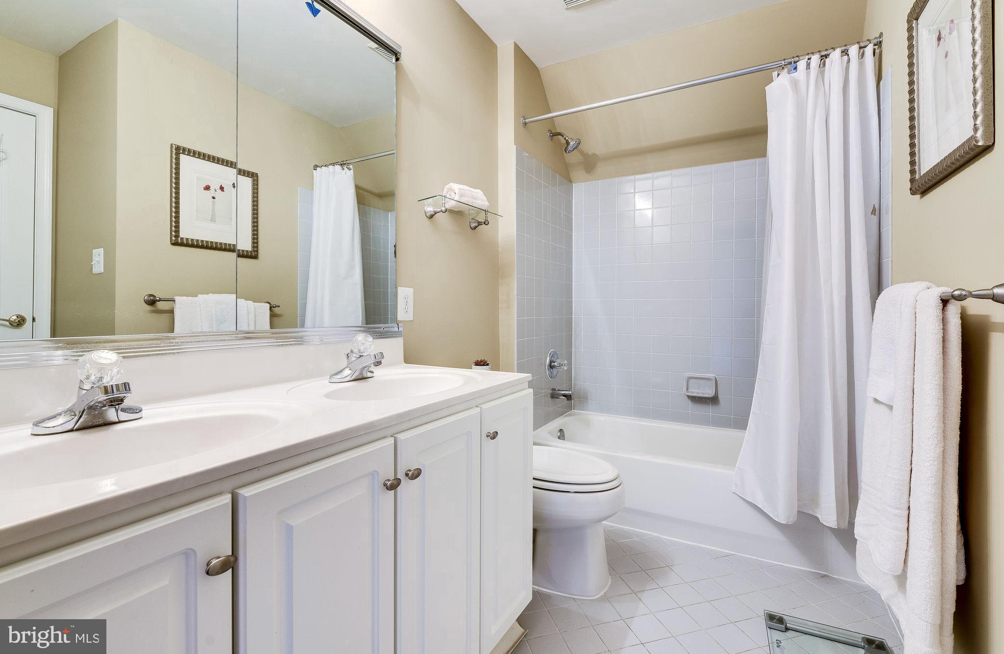 1701 Raleigh Hill Road Vienna, VA 22182 - Photo 40 of 61 a bathroom with a double vanity sink toilet mirror and bathtub