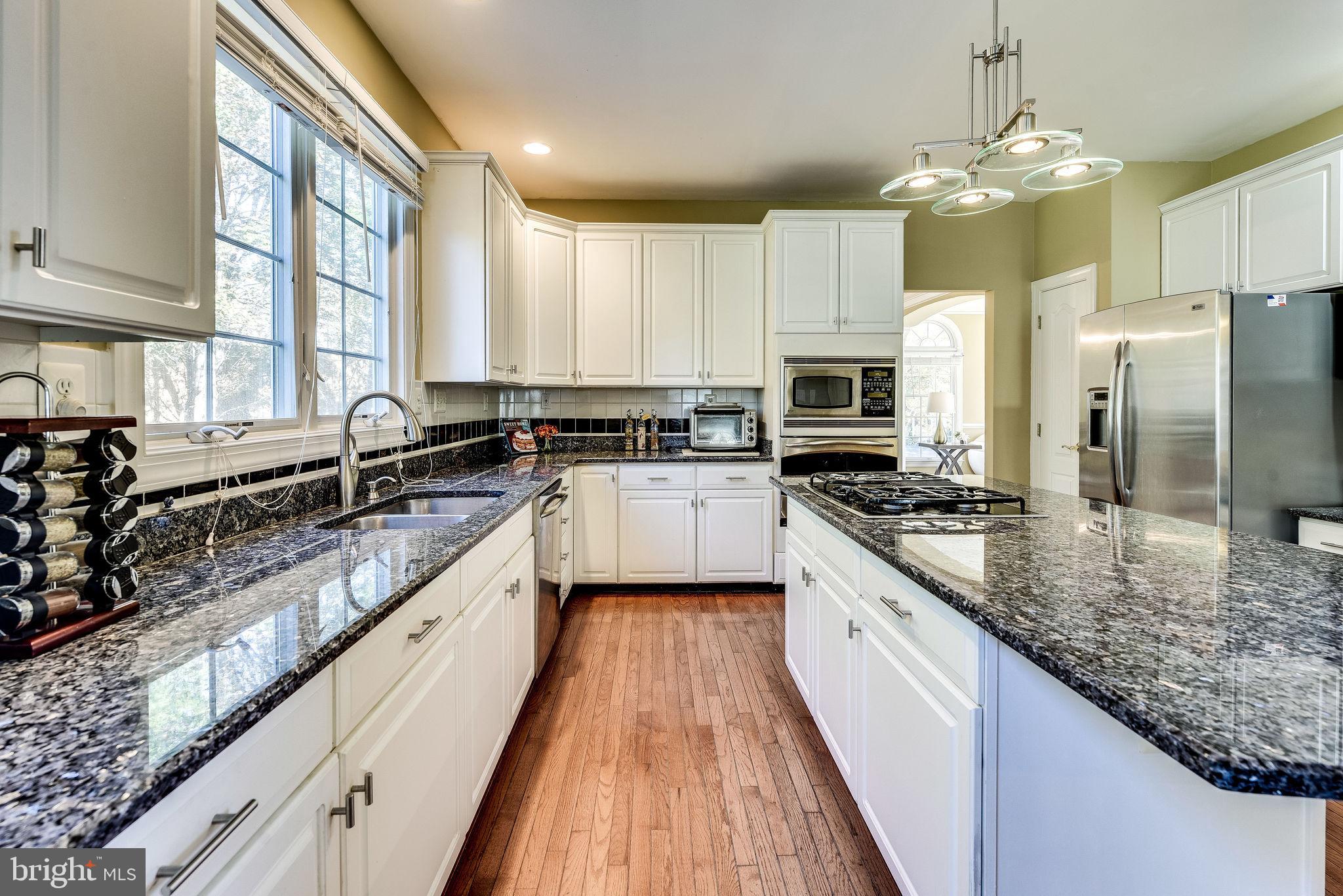 1701 Raleigh Hill Road Vienna, VA 22182 - Photo 5 of 61 a large kitchen with granite countertop a sink counter space stainless steel appliances and cabinets