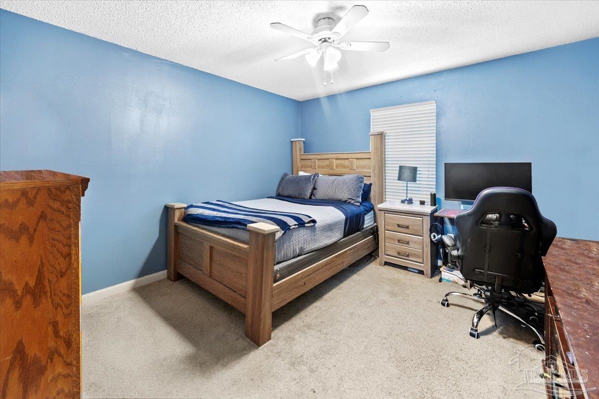 8617 Blue Jay Way Pensacola, FL 32534 - Photo 11 of 28 a bedroom with a bed and a chandelier