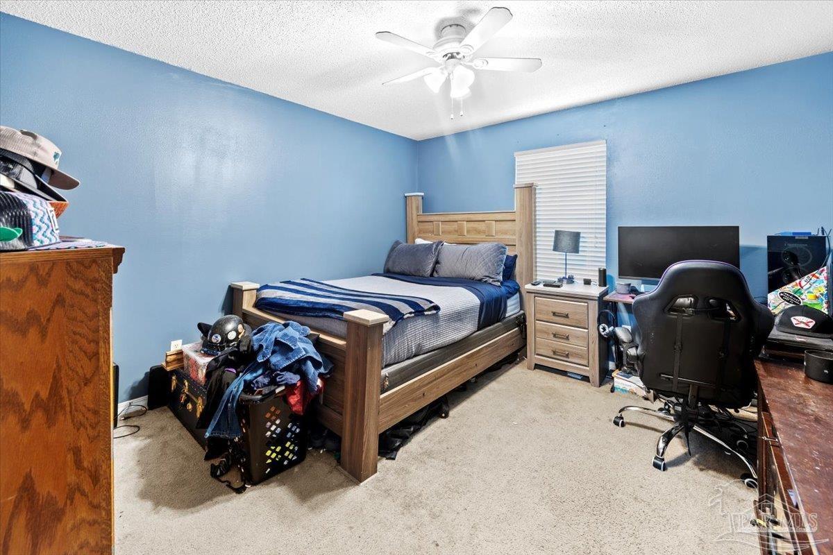 8617 Blue Jay Way Pensacola, FL 32534 - Photo 12 of 28 a bed room with a bed and a chair