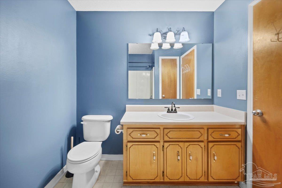 8617 Blue Jay Way Pensacola, FL 32534 - Photo 13 of 28 a bathroom with a sink vanity mirror and toilet