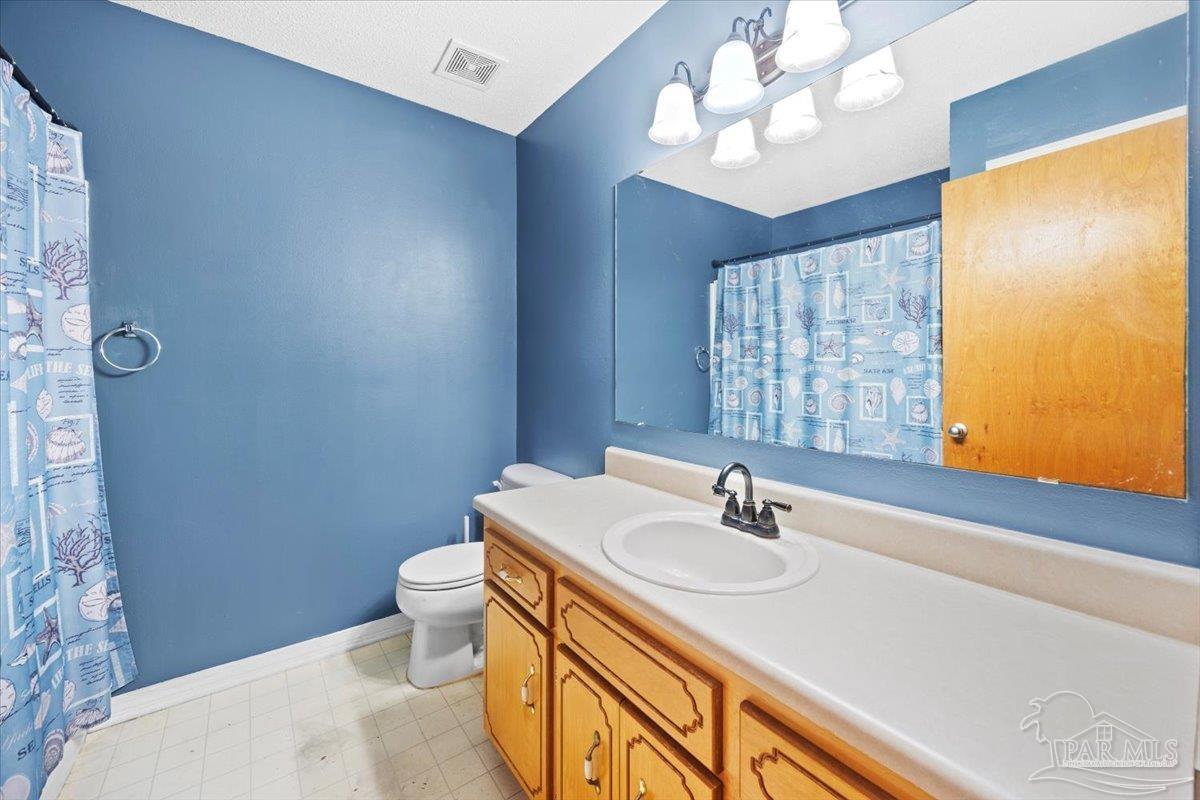 8617 Blue Jay Way Pensacola, FL 32534 - Photo 14 of 28 a bathroom with a sink vanity mirror and toilet