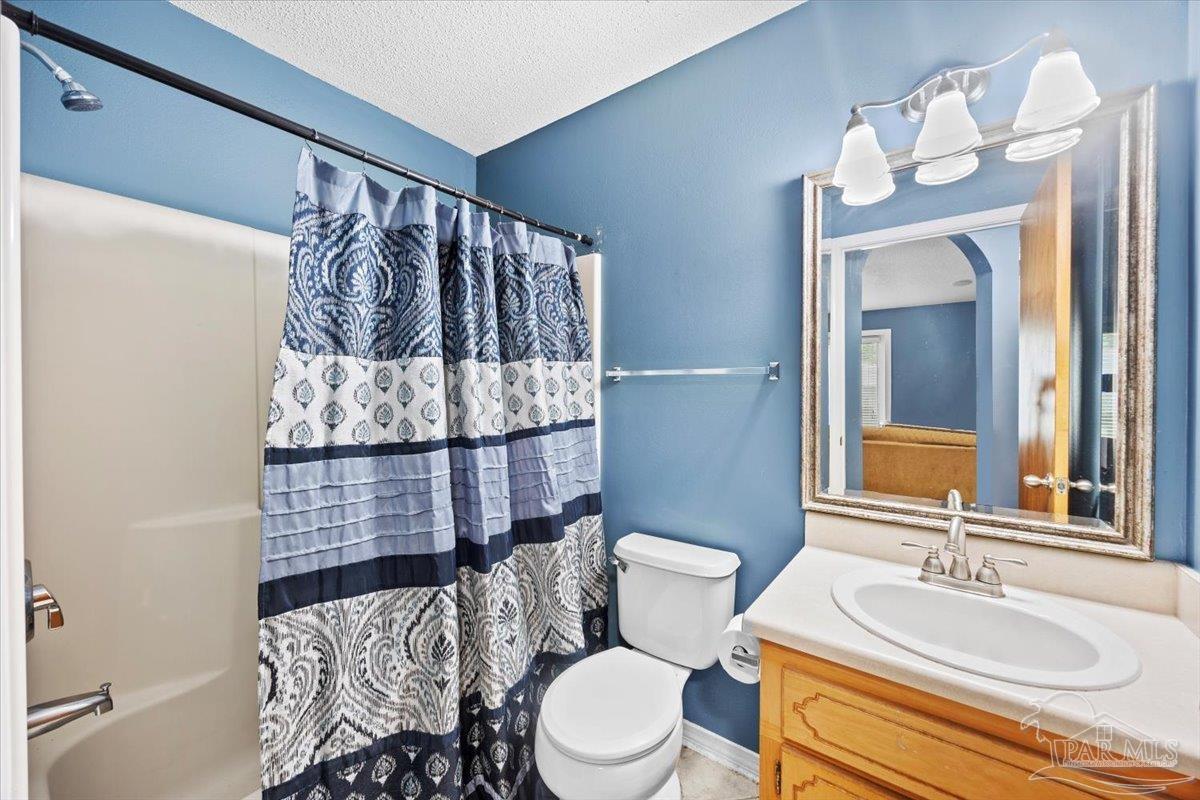 8617 Blue Jay Way Pensacola, FL 32534 - Photo 15 of 28 a bathroom with a sink a toilet and mirror