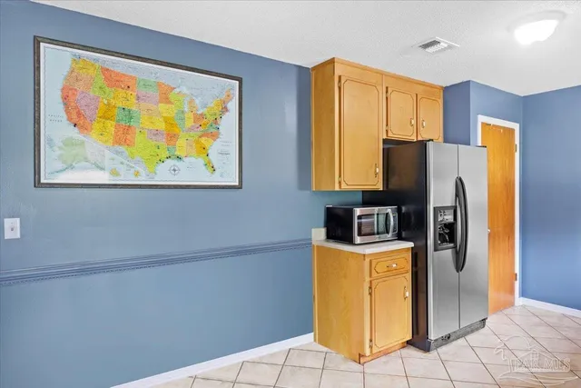 a view of a kitchen with fridge and wooden floor