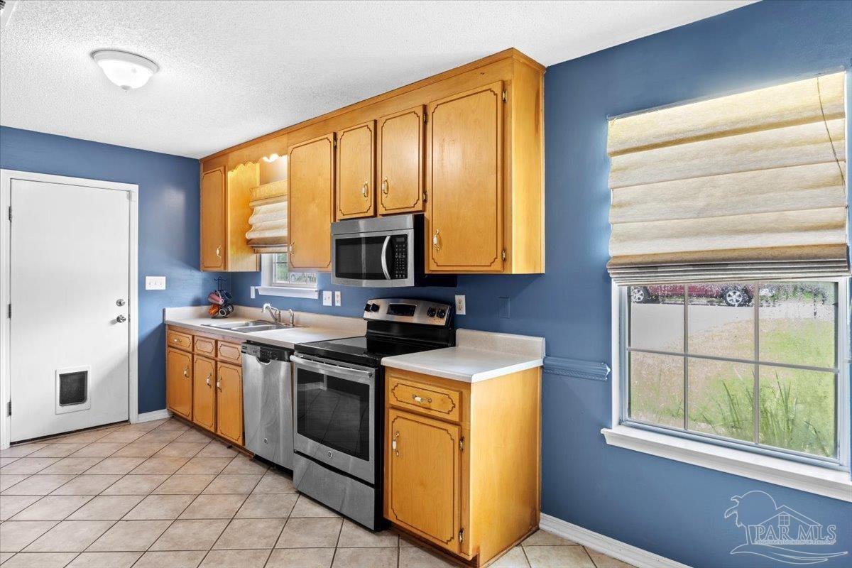 8617 Blue Jay Way Pensacola, FL 32534 - Photo 7 of 28 a kitchen with stainless steel appliances granite countertop a stove a sink and a microwave