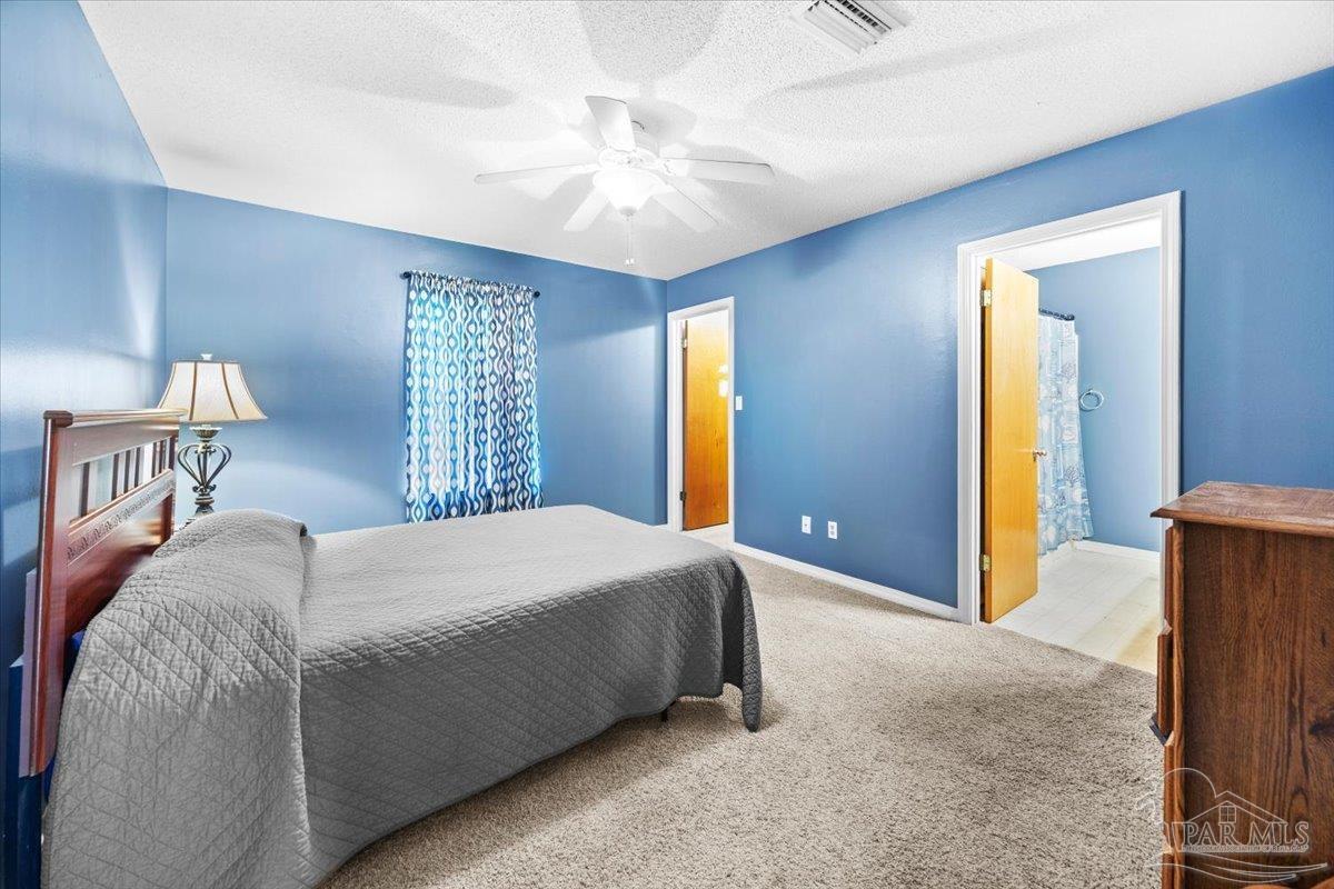 8617 Blue Jay Way Pensacola, FL 32534 - Photo 10 of 28 a bedroom with a large bed and a chandelier