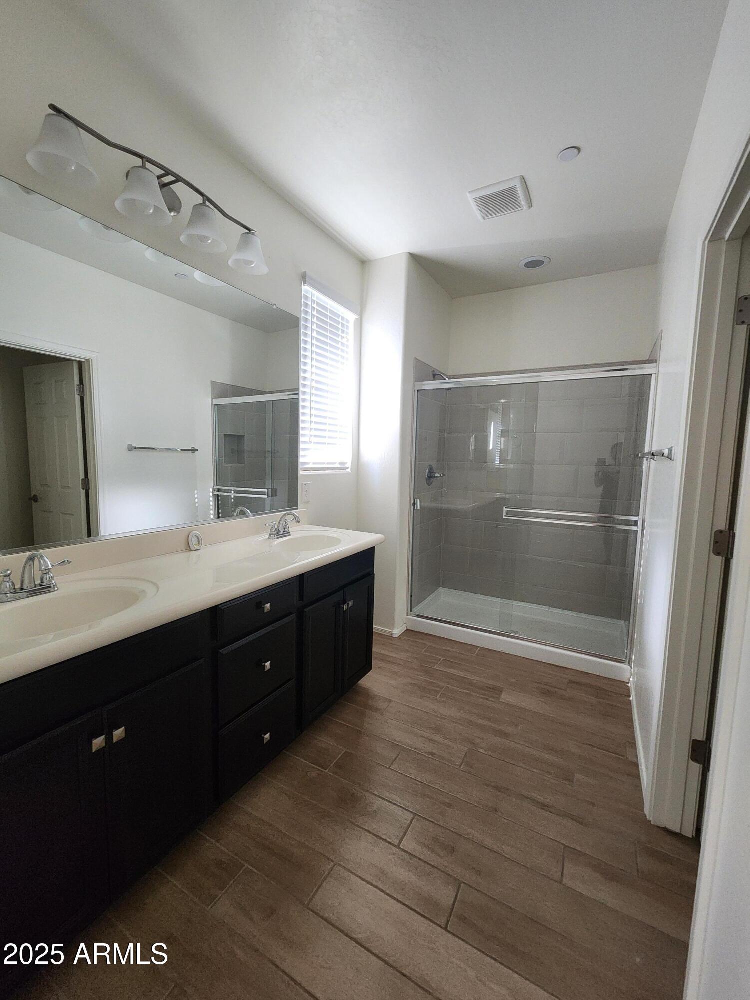 14870 West Encanto Boulevard, Unit 1113 Goodyear, AZ 85395 - Photo 26 of 33 a bathroom with a double vanity sink a toilet and a mirror