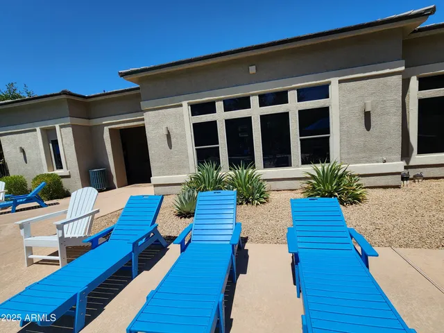 a view of a patio with couches chairs under an umbrella