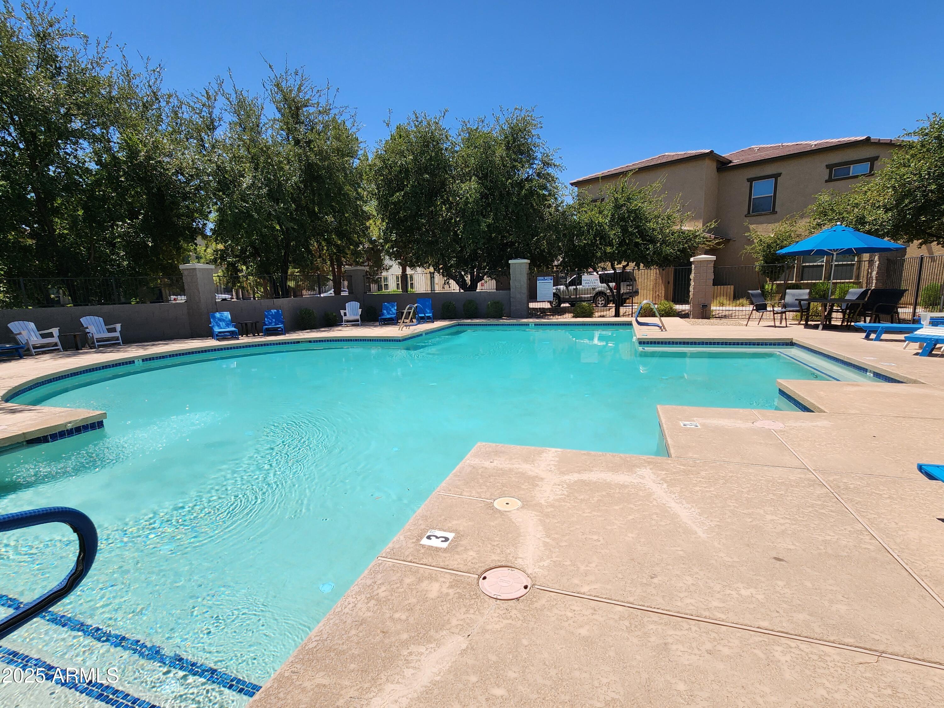14870 West Encanto Boulevard, Unit 1113 Goodyear, AZ 85395 - Photo 31 of 33 a front view of a house with swimming pool garden and outdoor seating