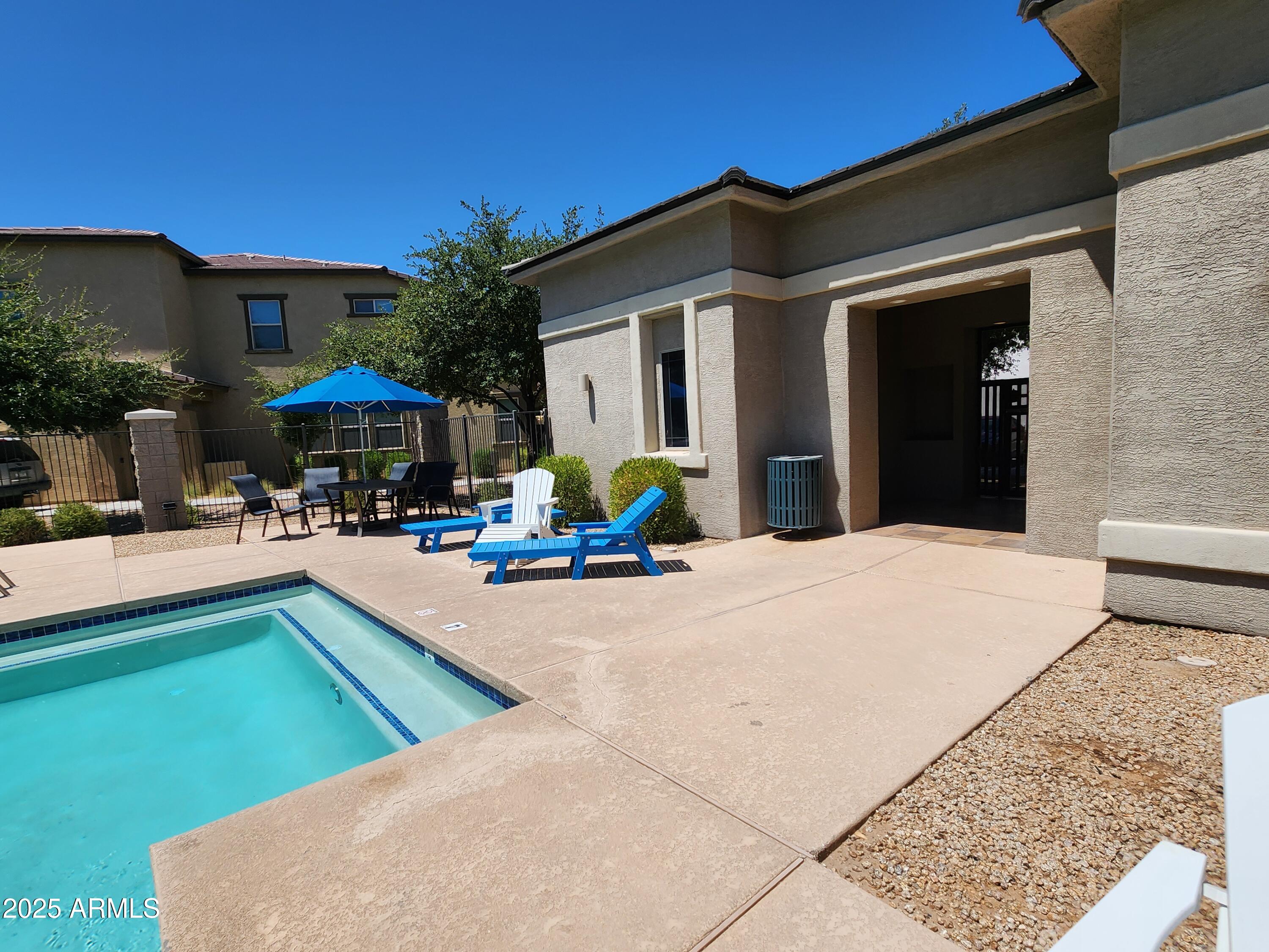 14870 West Encanto Boulevard, Unit 1113 Goodyear, AZ 85395 - Photo 32 of 33 a view of a patio with couches chairs under an umbrella